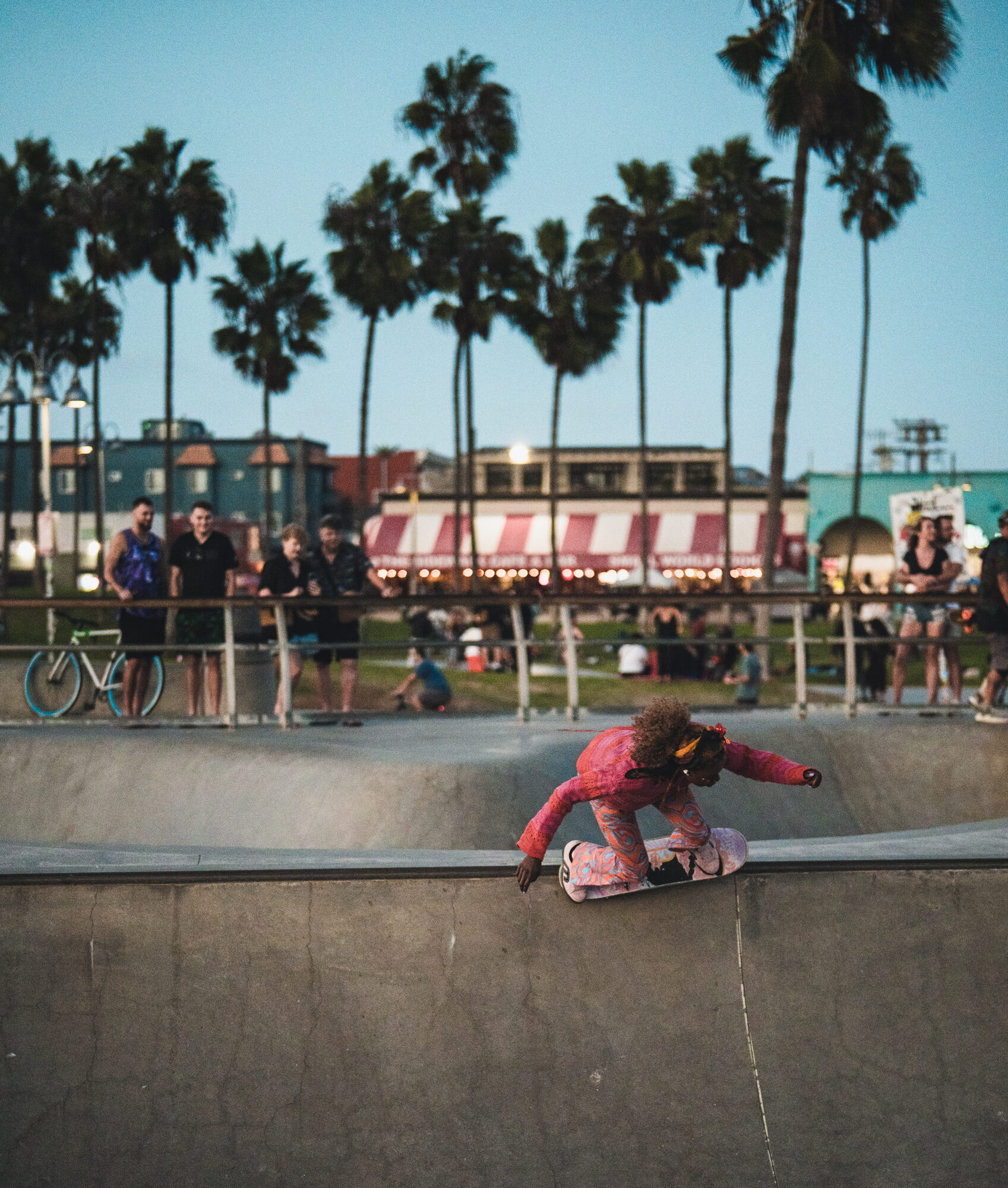 A skater moving through the Venice Skatepark bowl